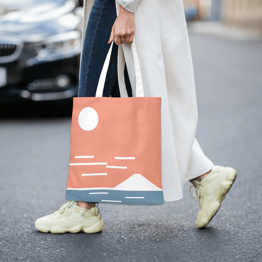 Person holding a tote bag with a design on a street