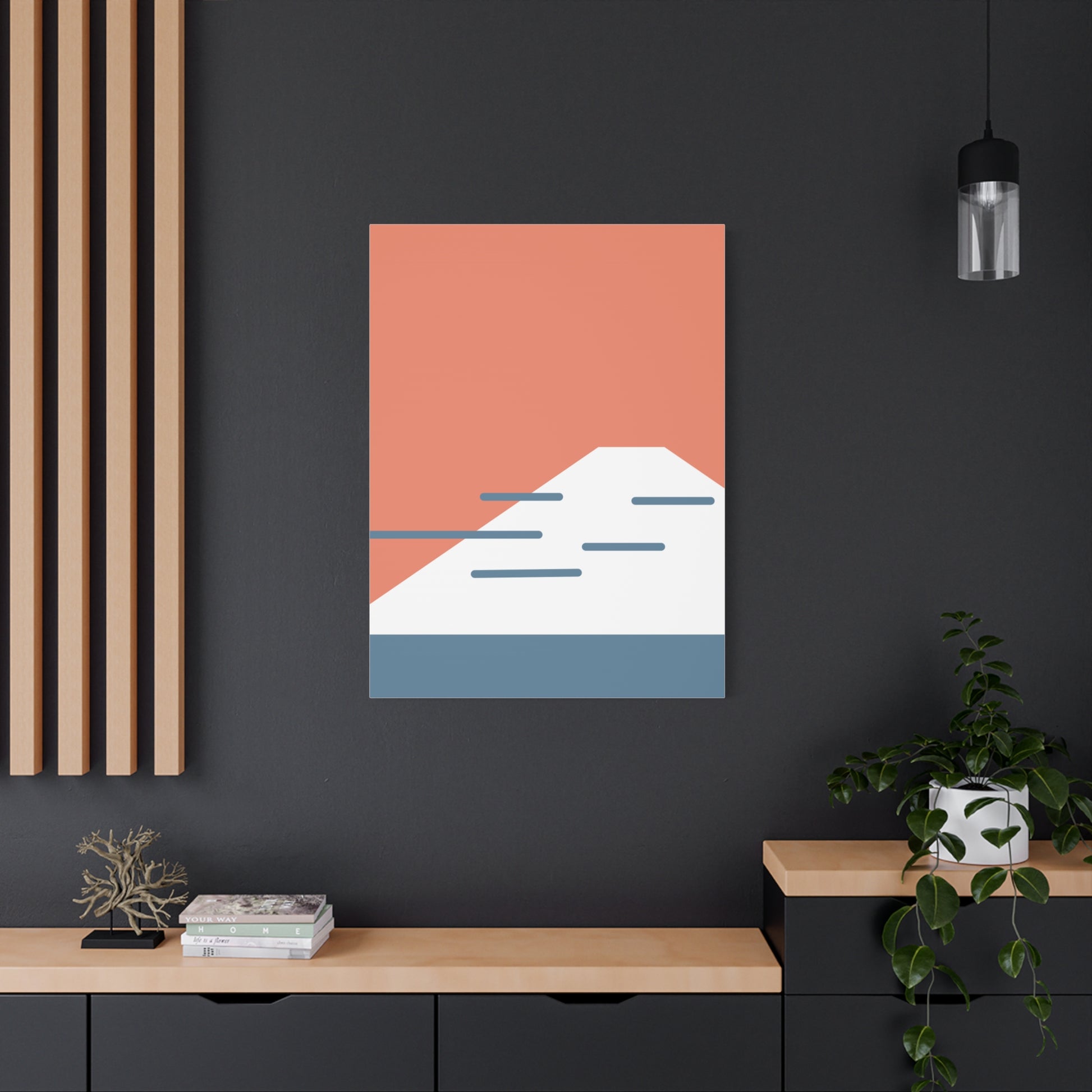 Abstract wall art with geometric shapes on a dark wall, below a light fixture.