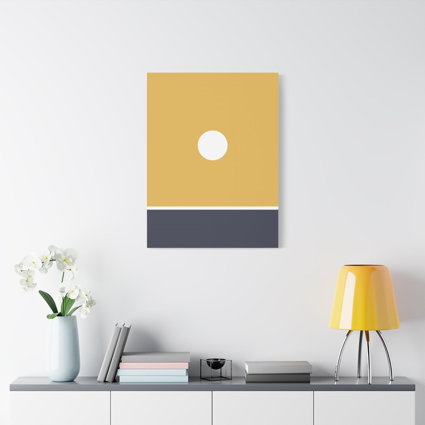 Yellow and gray abstract wall art on a white wall above a shelf with decor items.