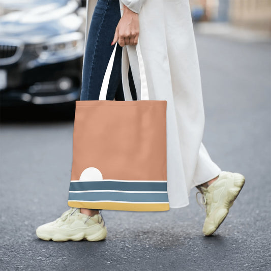 Person holding a brown tote bag with a striped pattern on a street.