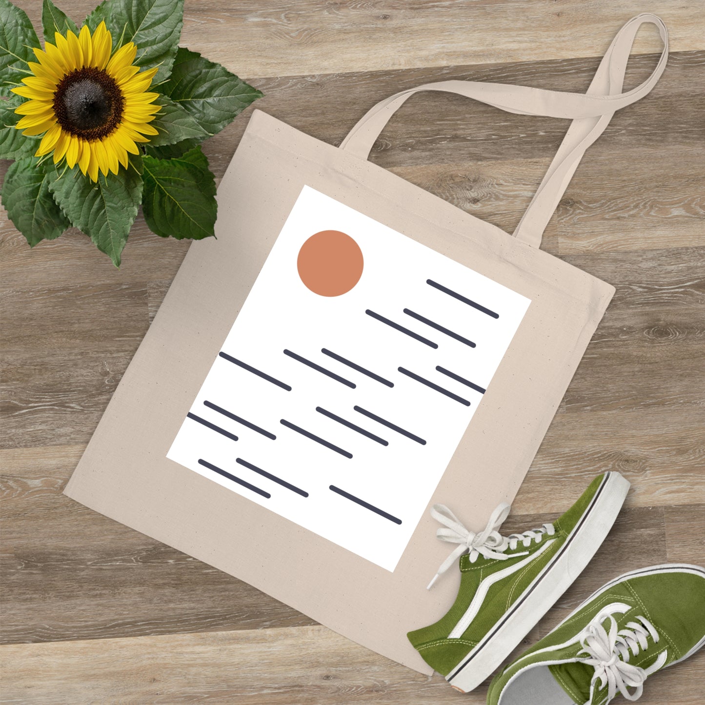Tote bag with a paper, sunflower, and green sneakers on a wooden surface