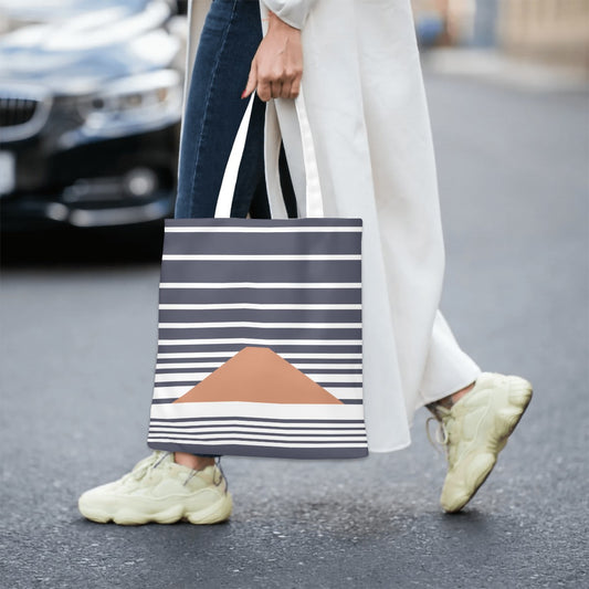 Person walking on a street holding a striped tote bag