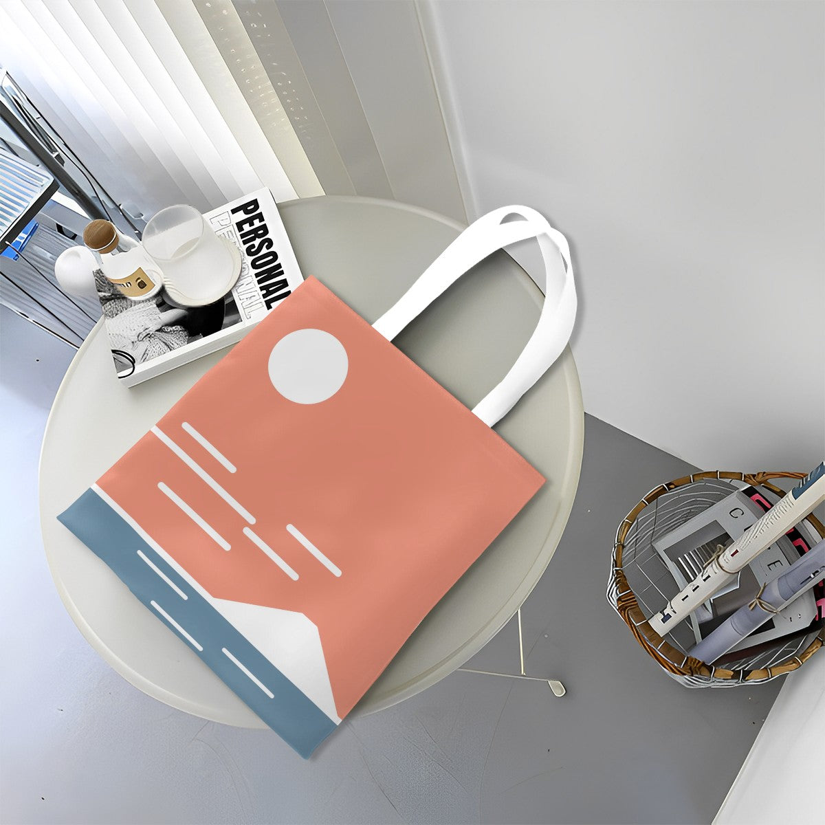 Pink tote bag with white handle on a round table with books and a magazine.