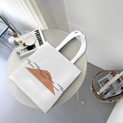 White tote bag with a geometric design on a round white table.