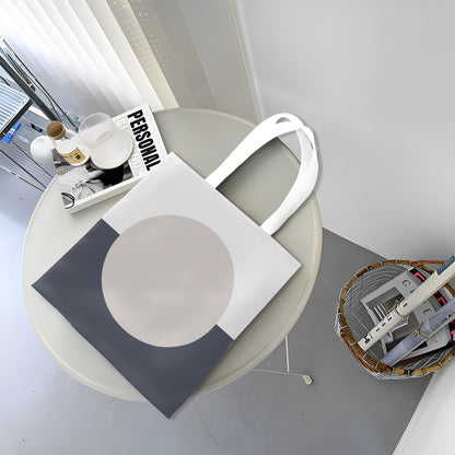 White tote bag with a gray circle design on a round table.