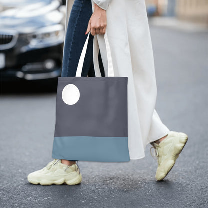 Person walking on a street holding a two-tone tote bag.